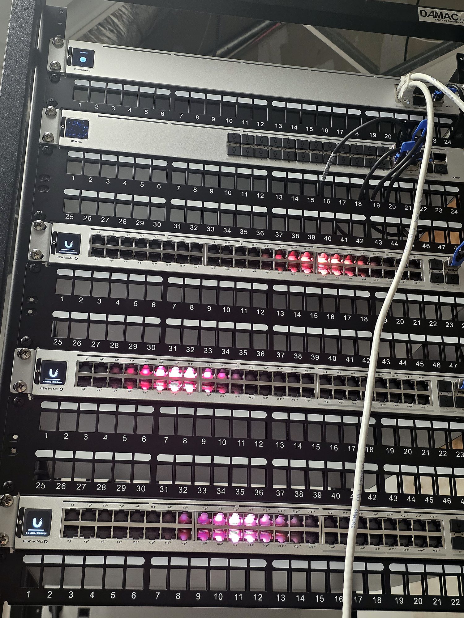 Miclyn network build in progress — UniFi gateway and switches with labeled patch panels during structured cabling and switch deployment