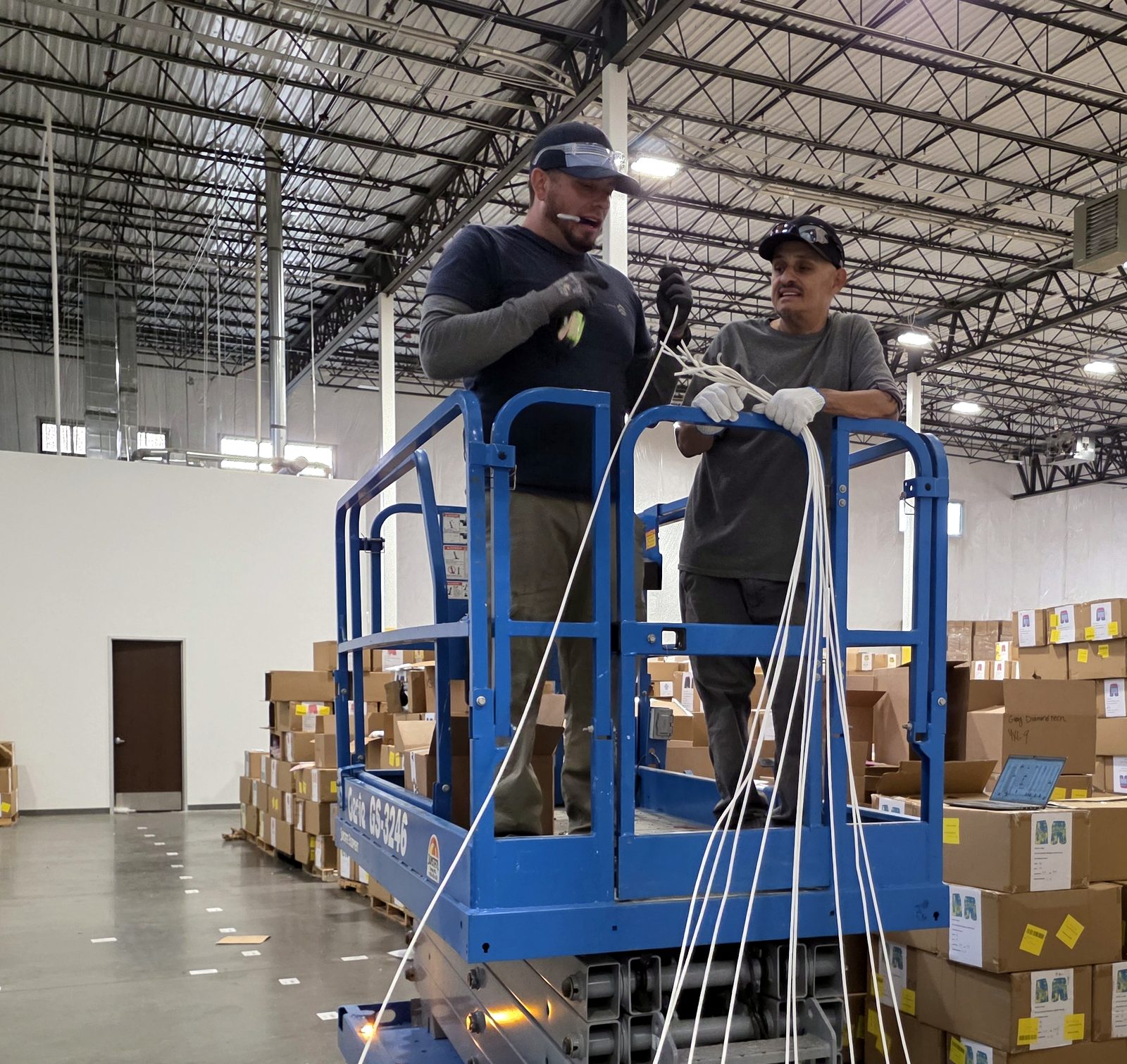 Miclyn technicians on a lift running network cabling in a New Mexico commercial building