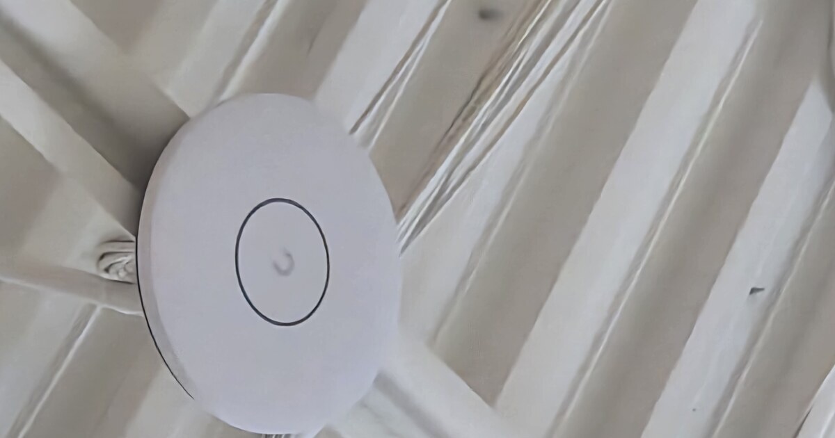 A business Wi-Fi access point mounted on an office ceiling