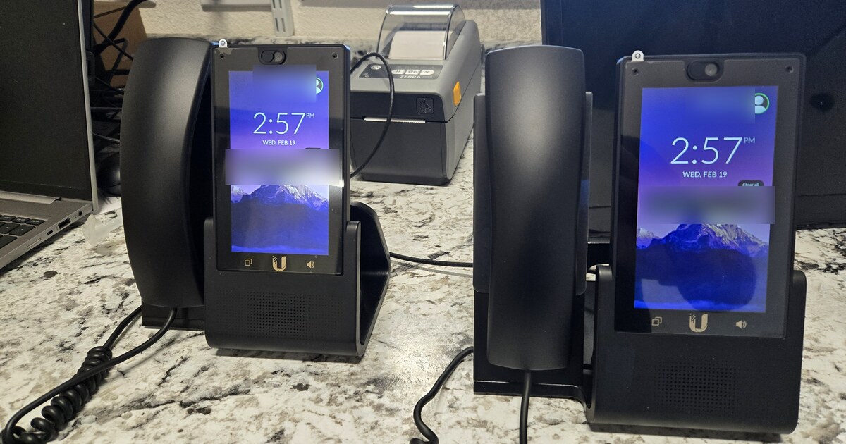 Two business VoIP desk phones on an office counter